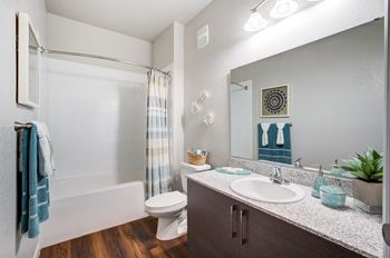 A bathroom with a toilet, sink, and mirror.
